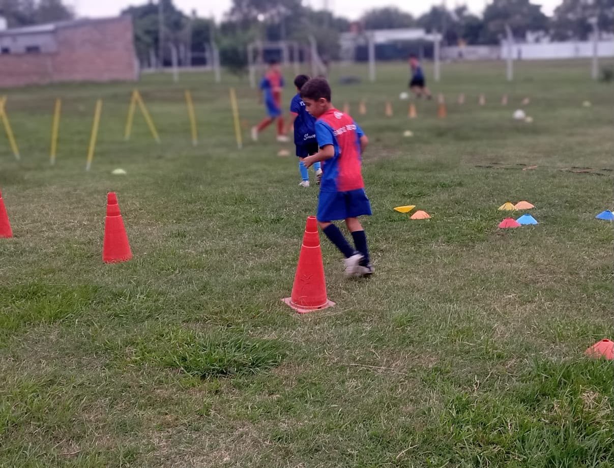 Chicos entrenando con conos y estacas