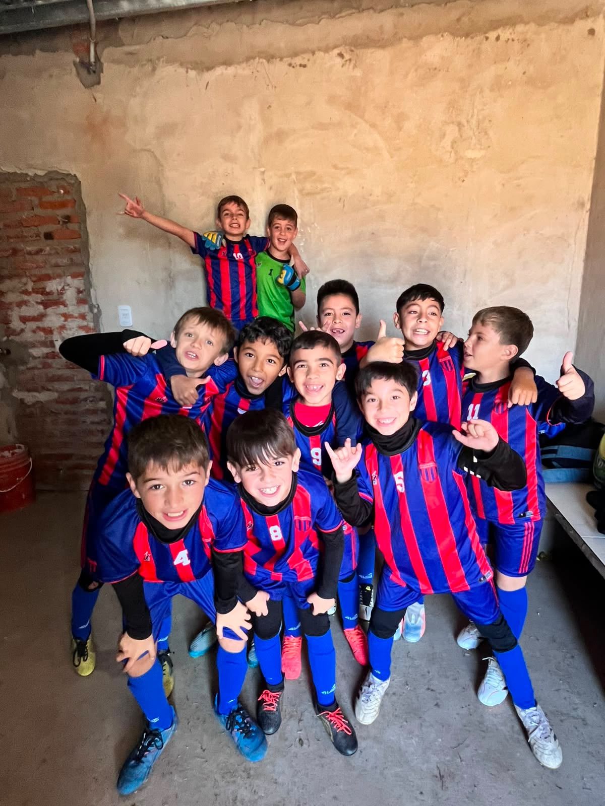 Chicos festejando y sonriendo en el vestuario
